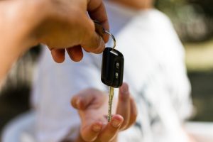 A car key being handed over to a buyer