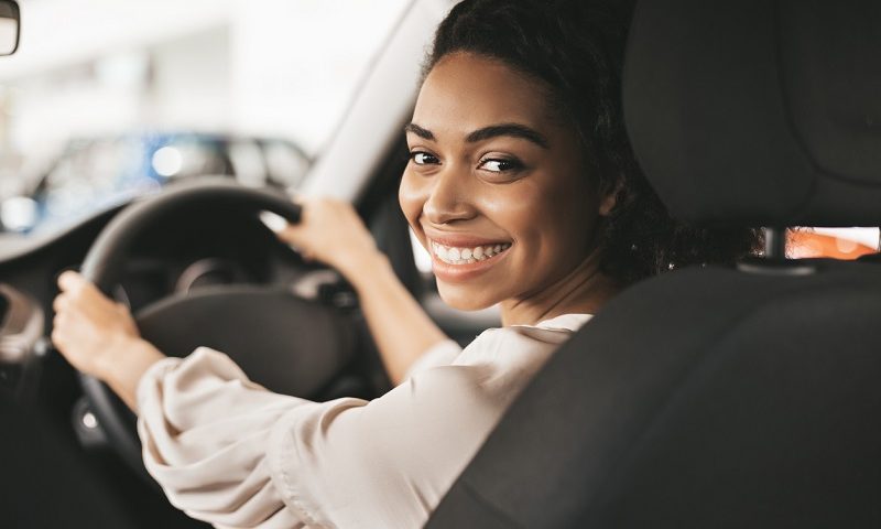 Smiling young woman driving