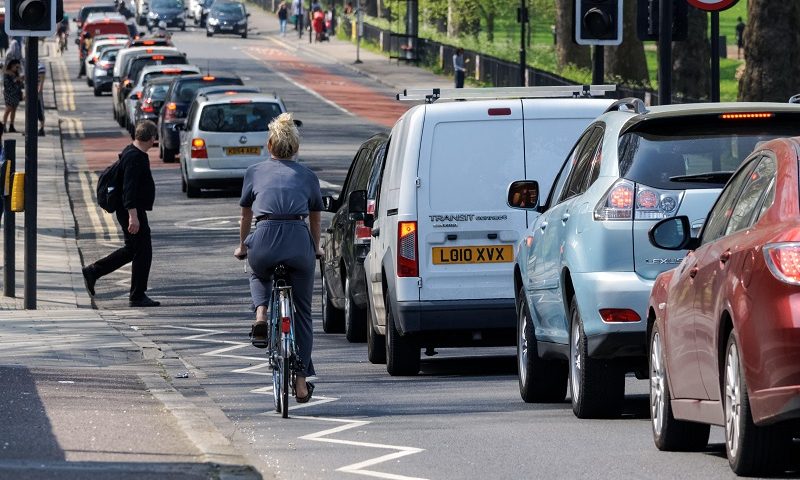 Cyclist and pedestrian on congested London road
