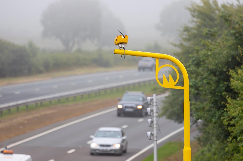 Drivers pass beneath a yellow average speed camera