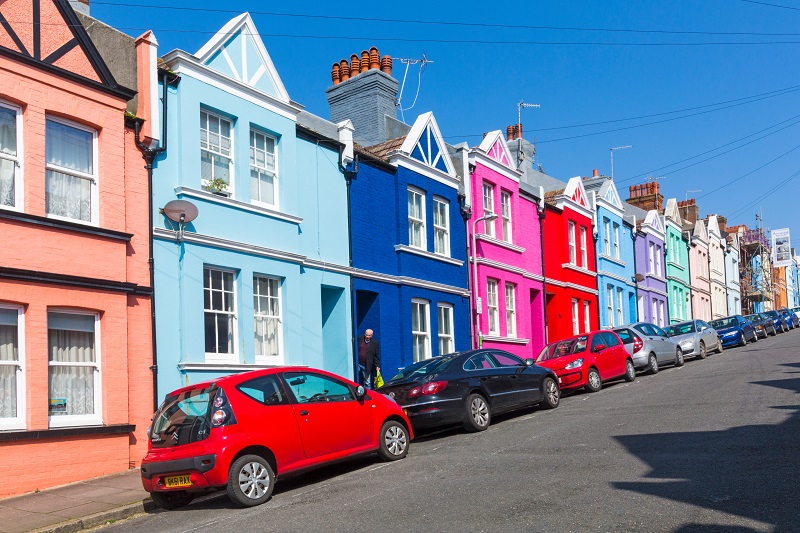Colourful terraced houses with cars parked outside