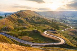 Winding road and hills at sunset in the Peak District