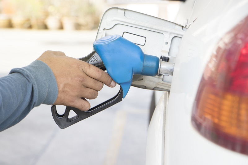 Person filling car with fuel at a station