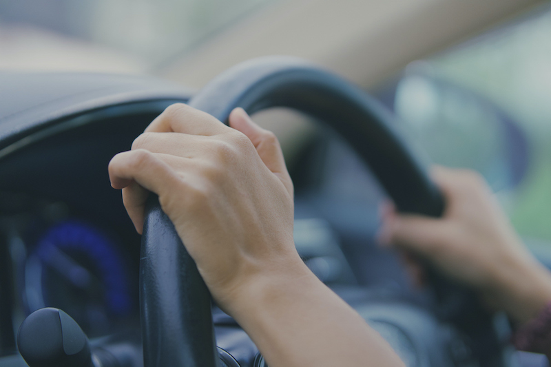 Woman’s hands on steering wheel
