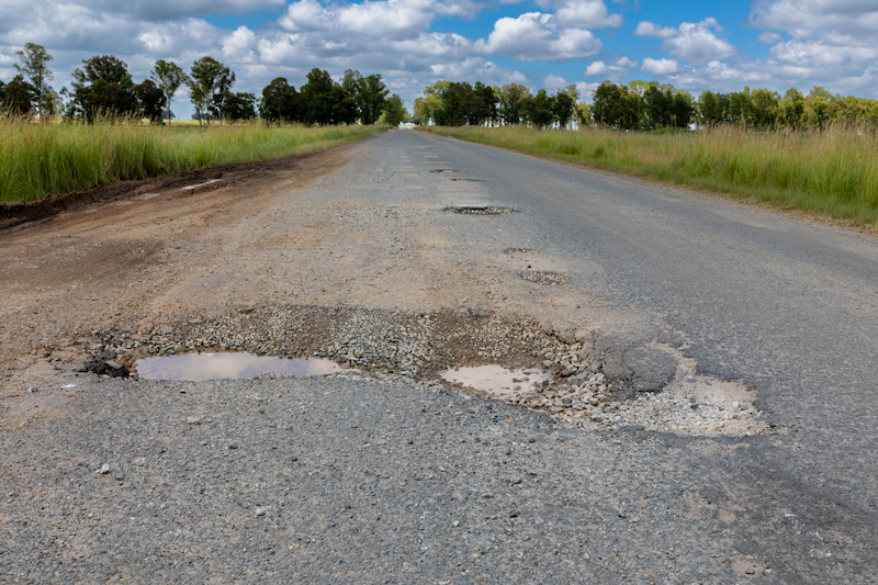 Several potholes on a country road