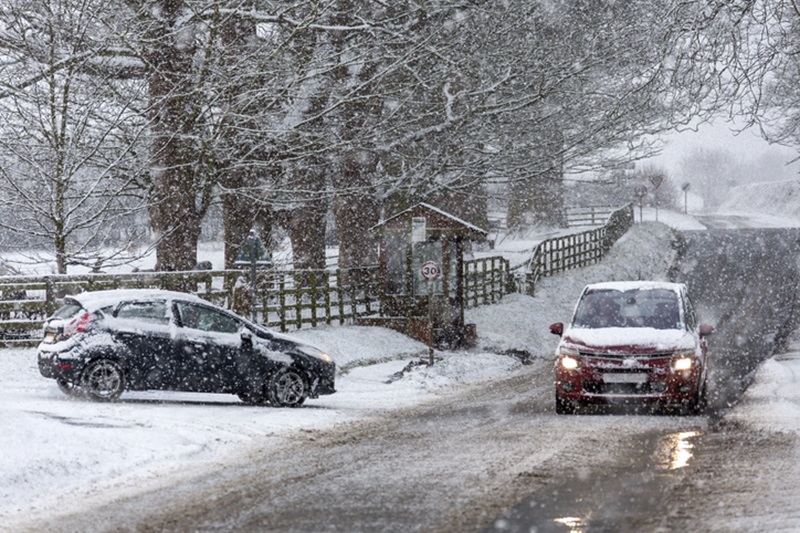 Two cars in the heavy snow on a road in North Yorkshire.