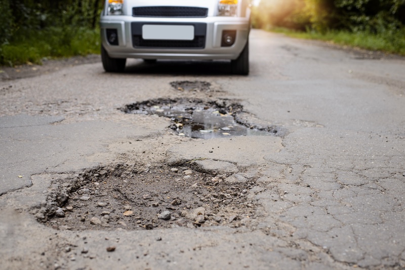 Several large potholes on a country road