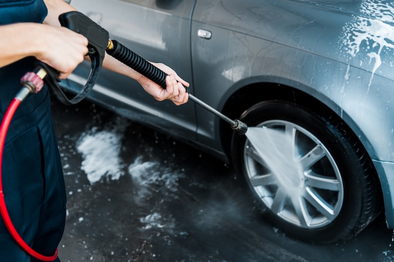 Someone pressure washing the wheel of their car