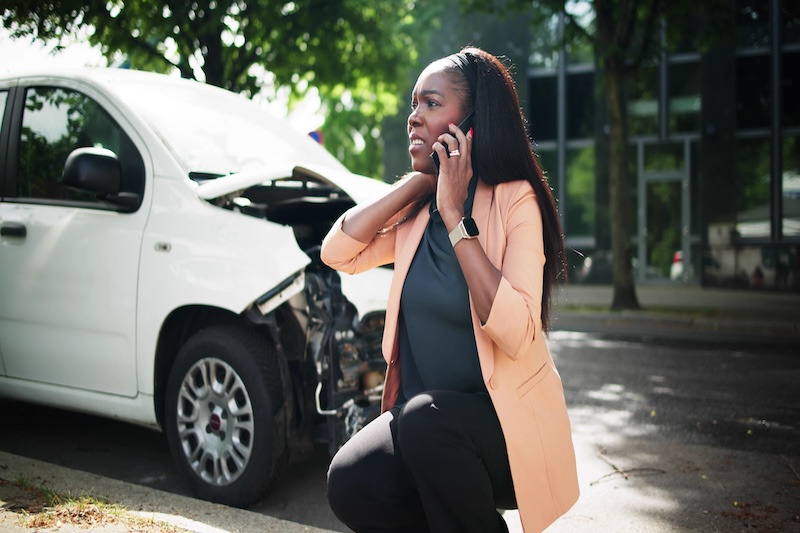 A woman making a call after being in a car accident.